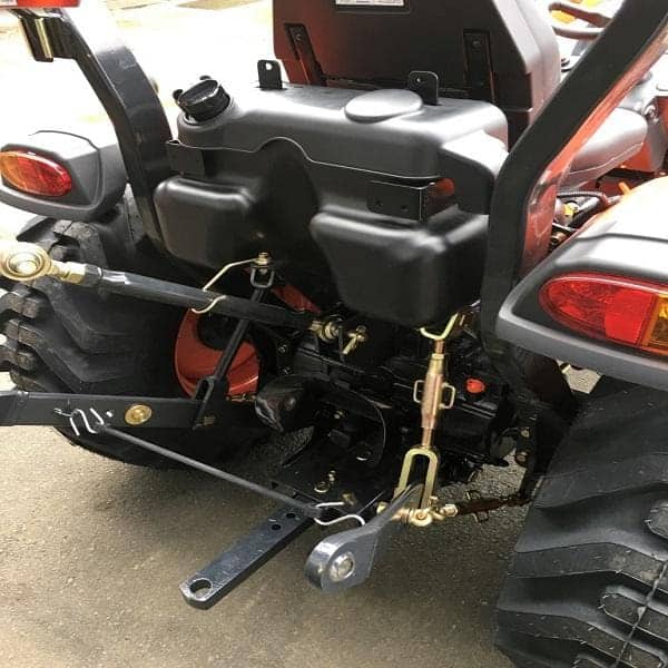 Close-up of Kioti CK2610 3-point hitch assembly and lift arms.